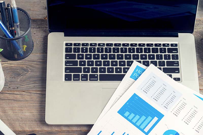 Laptop, report papers, pens